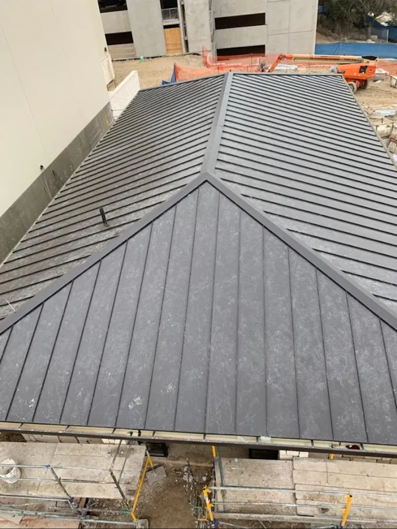 Commercial metal roof construction with crane equipment in Denison