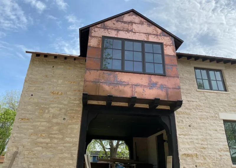 Copper metal panel facade on a stone building for Skylight Installation in Denison